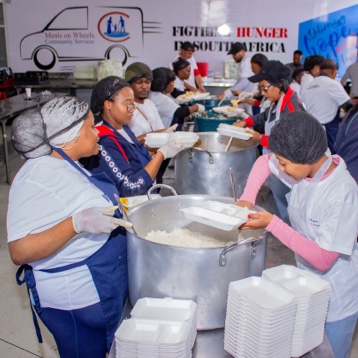 Employees dishing meals for the less fortunate.